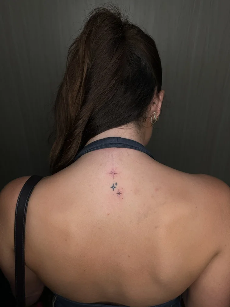 fineline star symbol woman back tattoo black line elegant tattoo canggu bali