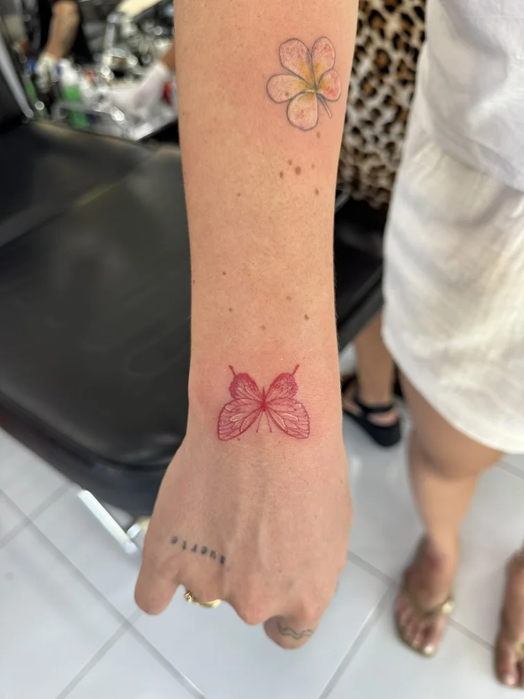 woman hand butterfly red fine line line animal tattoo canggu bali